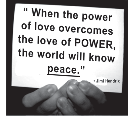 Fotografia em preto e branco de mãos entrelaçadas segurando um cartaz com a citação: '"When the power of love overcomes the love of POWER, the world will know peace." — Jimi Hendrix' (Quando o poder do amor superar o amor pelo poder, o mundo conhecerá a paz.). A palavra 'peace' aparece sublinhada e 'POWER' em maiúsculas.